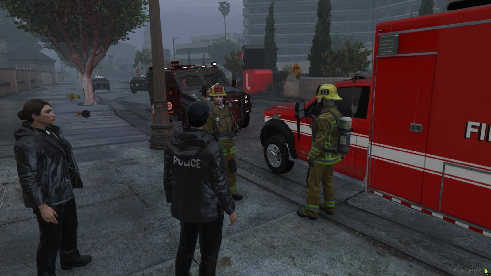 Police and fire crews gathered by an ambulance and armoured vehicle in fog