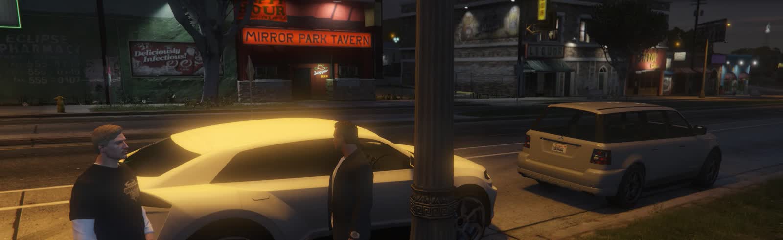 Two characters talking beside a parked car outside the Mirror Park Tavern at night