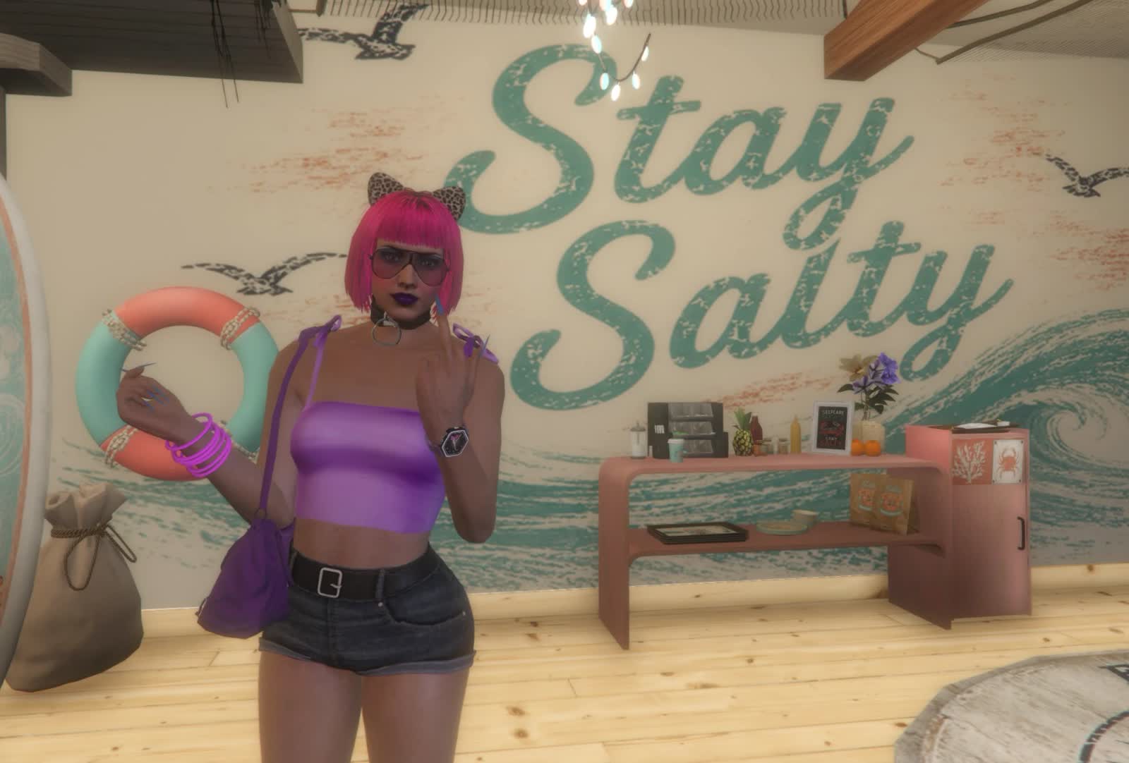 A character with bright pink hair posing in front of a Stay Salty mural in a beach shop