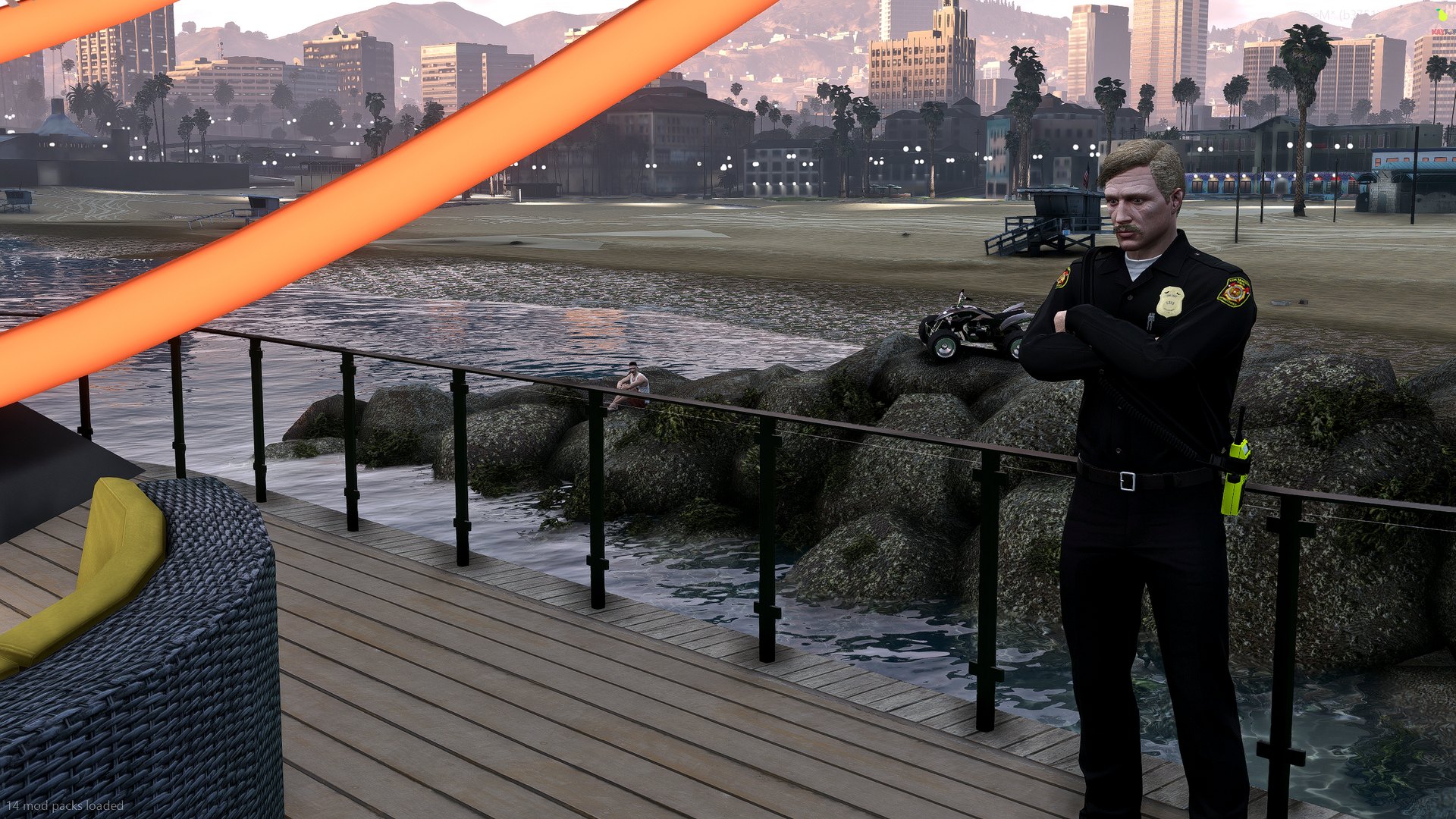 A police officer standing at the deck railing with arms folded, quad bike and city skyline behind